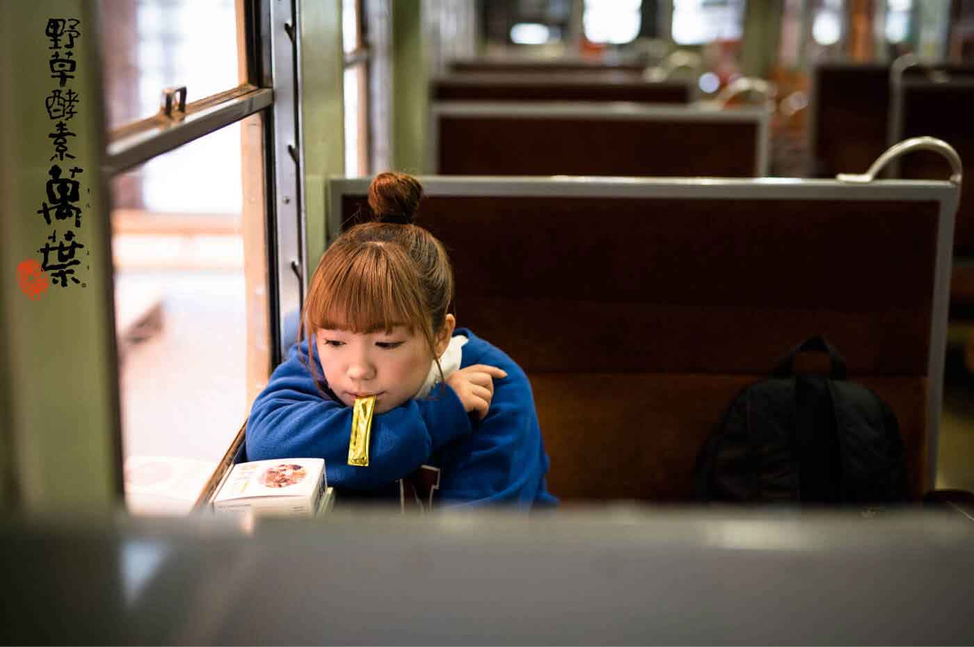 野草酵素萬葉濃縮練りを外出先で食べている女性